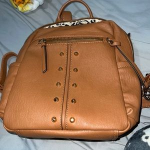 Chic studding completes this stylish faux leather cognac brown backpack